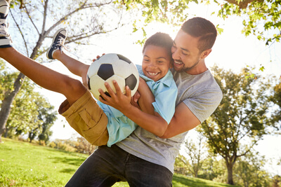 Father and son playing soccer