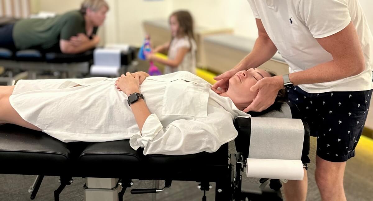 Mentone chiropractor adjusting a male patient's neck