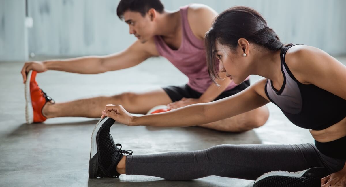 Male and female athletes stretching