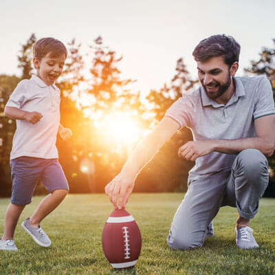 dad and son kicking football