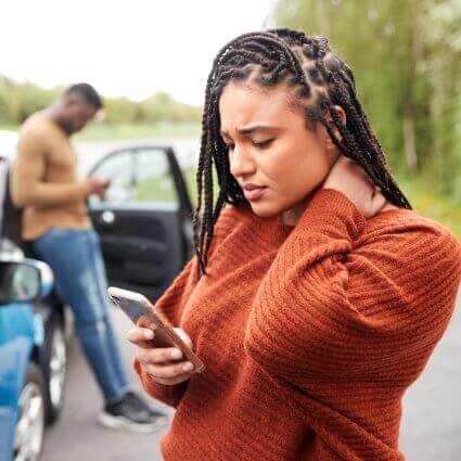 woman-checking-phone-after-car-accident-sq