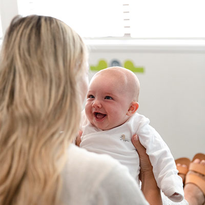 baby being held and smiling