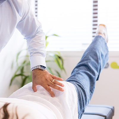 chiropractor with hand on a patients lower back