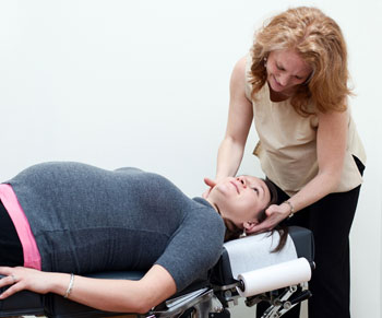 Dr. Jenny Komac adjusting pregnant patient.