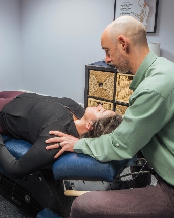 Male chiropractor treating his patient