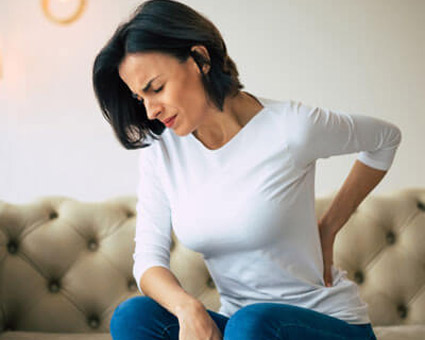 woman on fancy couch with back pain