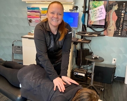 Chiropractic Care Smiling chiropractor adjusting a patient
