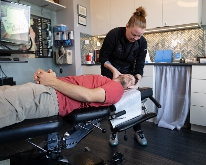 Chiropractor adjusting male patient's neck