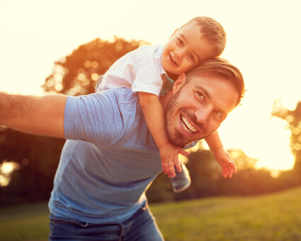 Little boy on dad's back width=