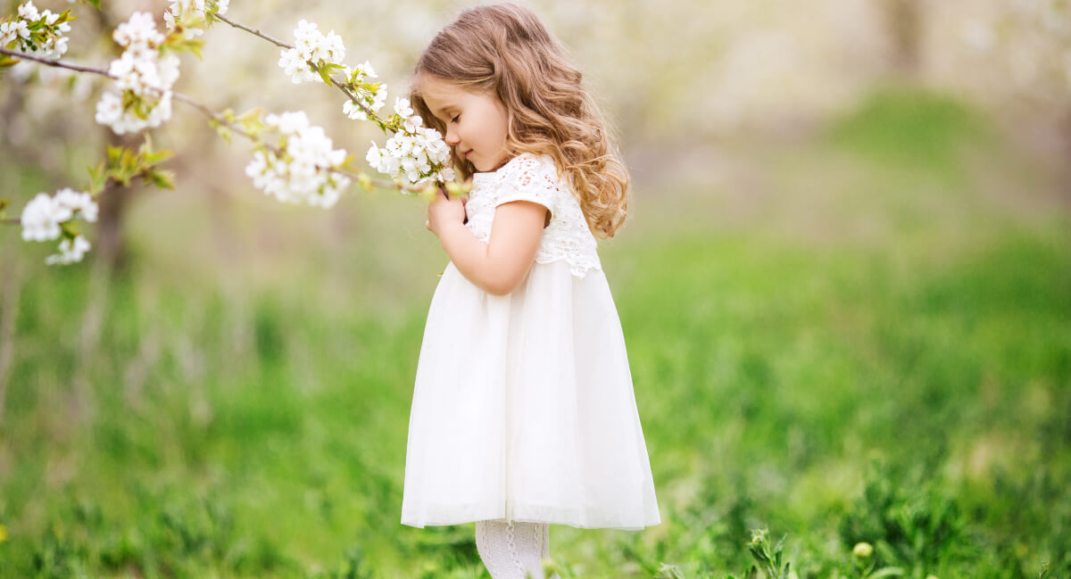 Little girl smelling flowers