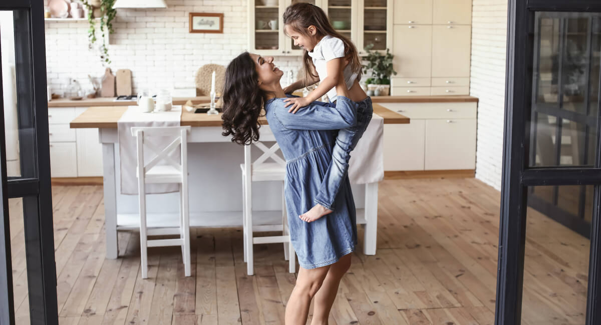 Mom lifting her young daughter