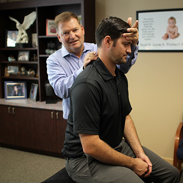 Dr. Stuckey checking the neck position of a chiropractic patient. 