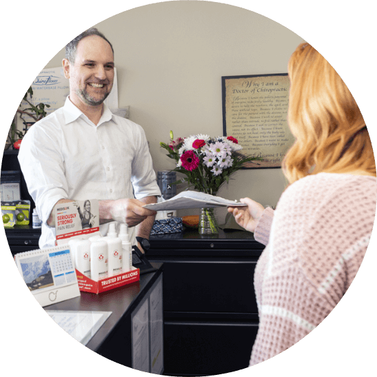 Calgary chiropractor Dr. Ryan greeting patient at front desk