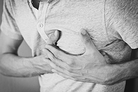 man holding his chest inpain