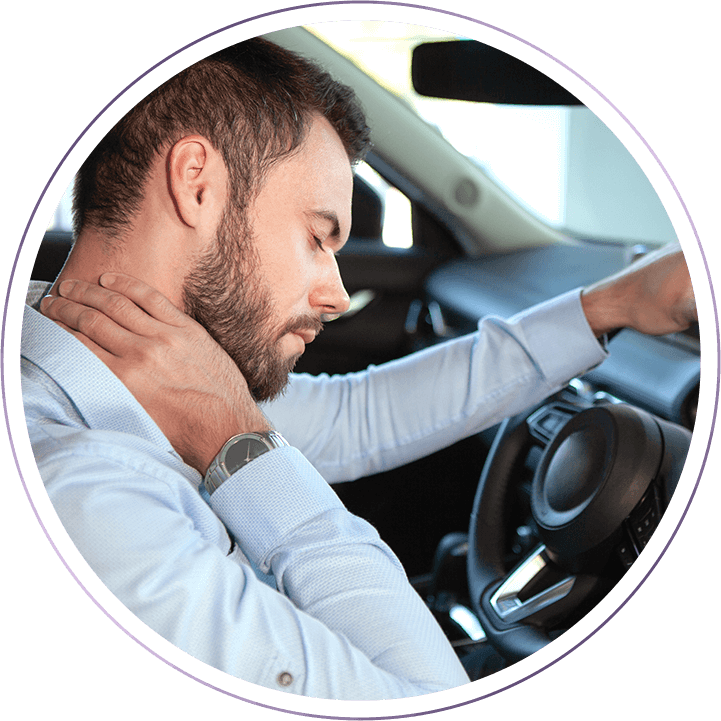 man sitting in car holding neck