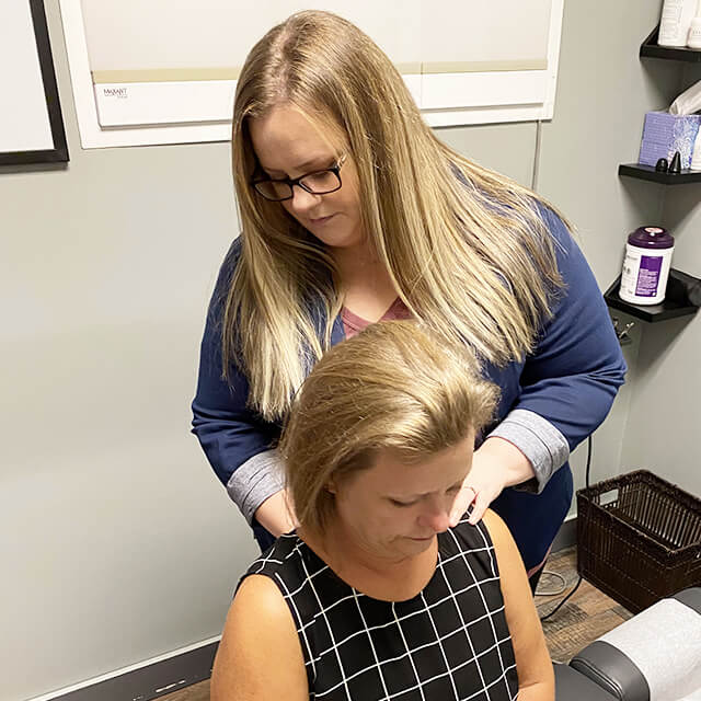 Dr. Michelle with hands on woman's neck