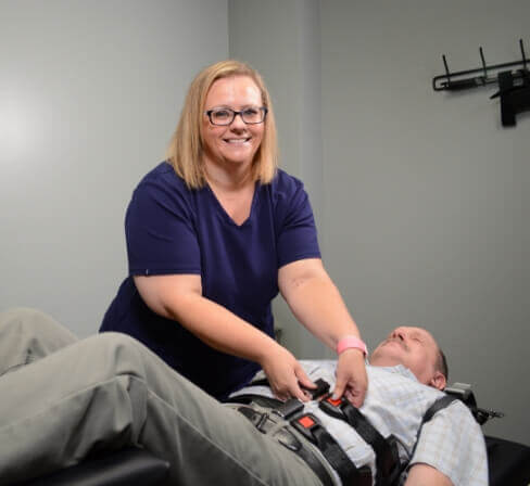 Back To Health Chiropractic Dr Pickett helping patient on adjusting table