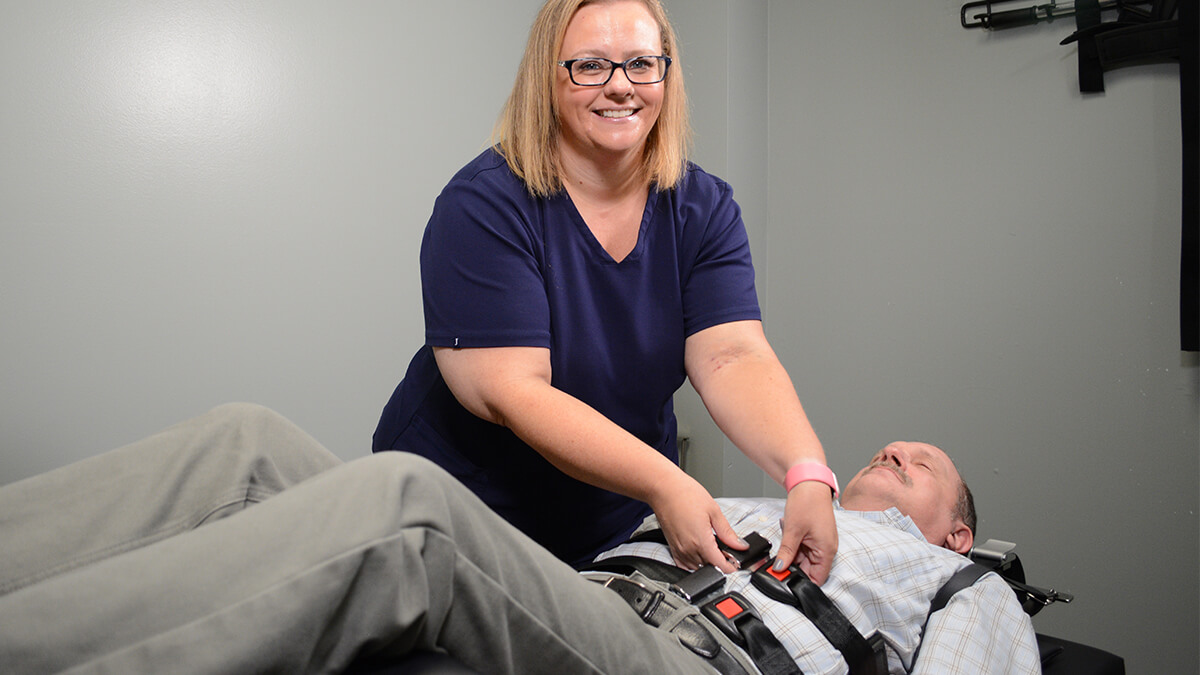 Mukilteo chiropractor Dr Pickett putting patient on adjusting table