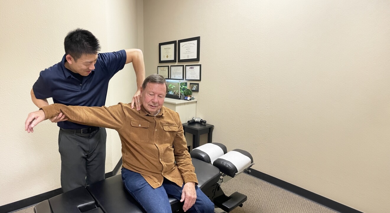 Dr. Lue adjusting patient's shoulder