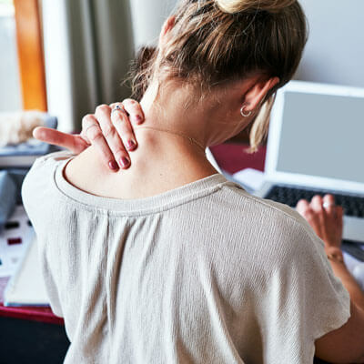 person sitting at a computer with a sore neck