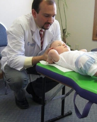 Dr. Marty Moore adjusting a pediatric patient