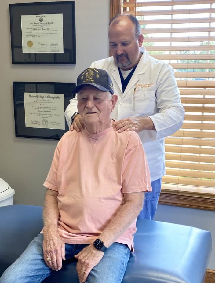 Chiropractor adjusting Wooster patient's shoulders
