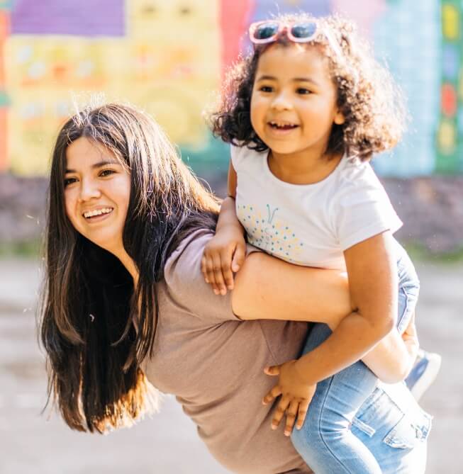 mom carrying daughter on her back