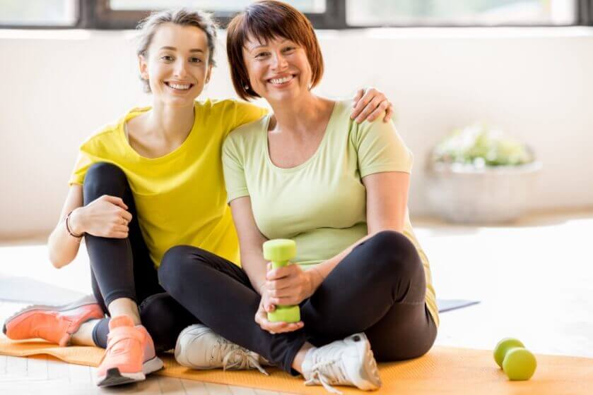 mother and daughter on exercise mat