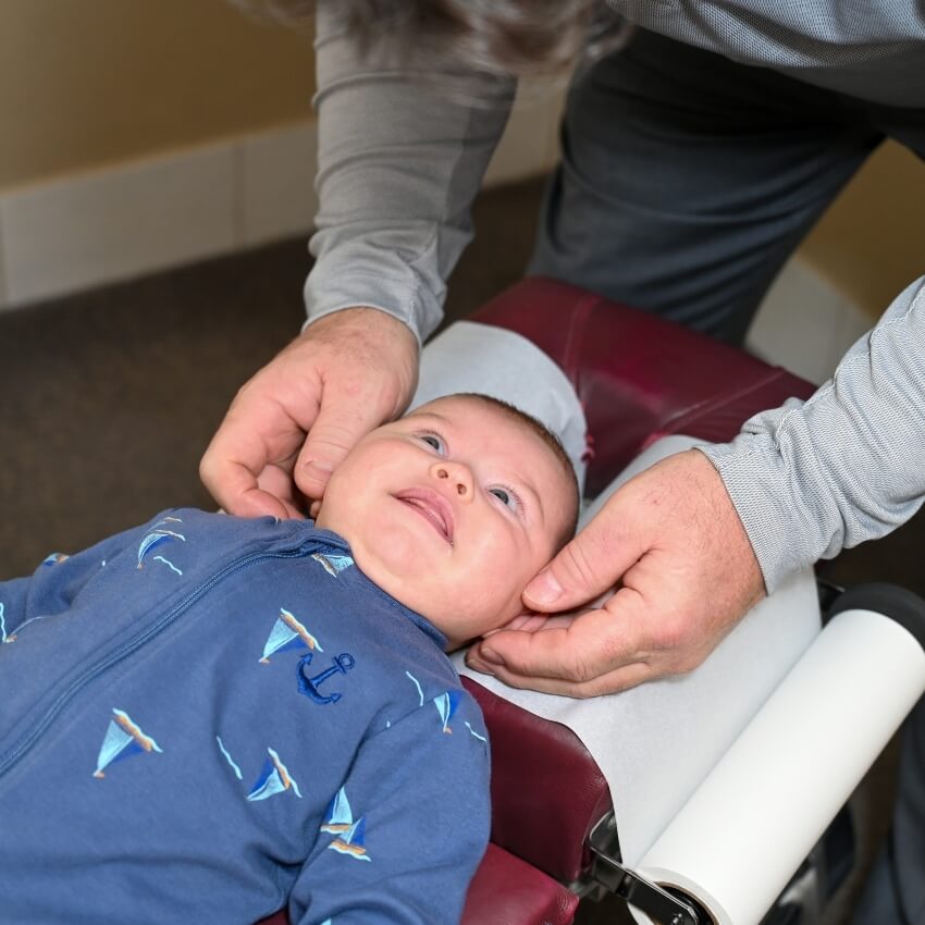 Dr Brett adjusting babys neck