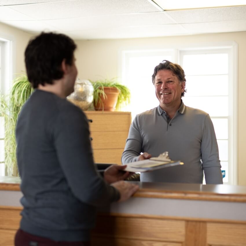 Dr Brett welcoming patient at the front desk
