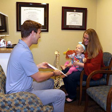 Doctor reviewing results with woman and her baby