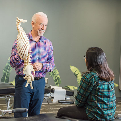 Dr. Dennis holding spine model