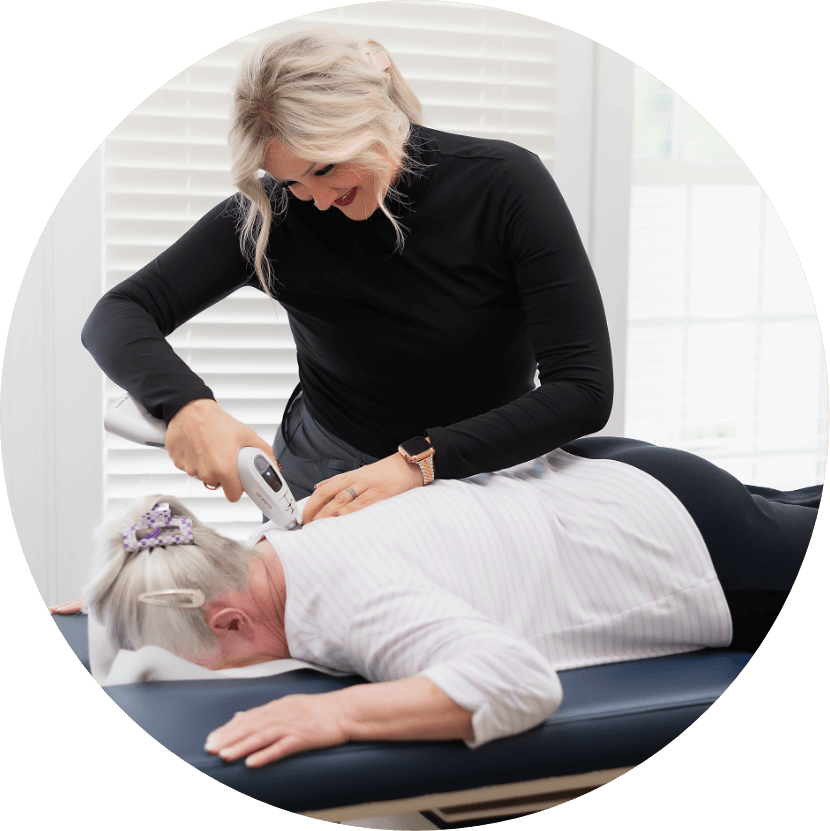 Chiropractor using tool on a patient