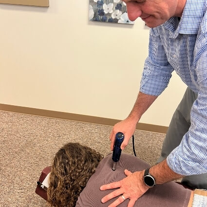 Dr houtz adjusting patients back with tool