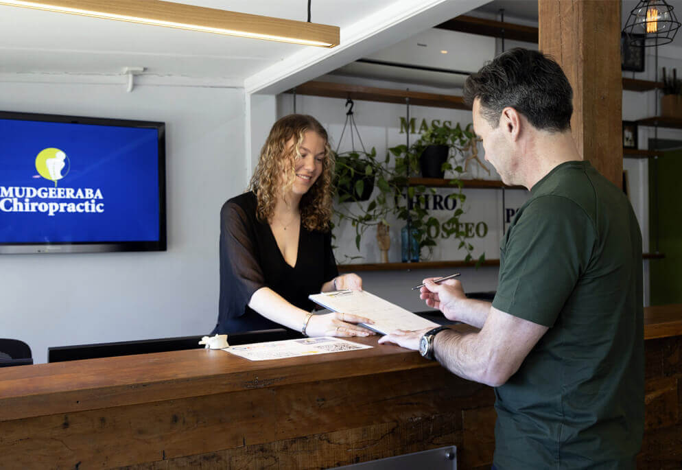 person signing papers at front desk