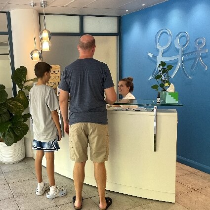 Father and son at Central To Health reception desk