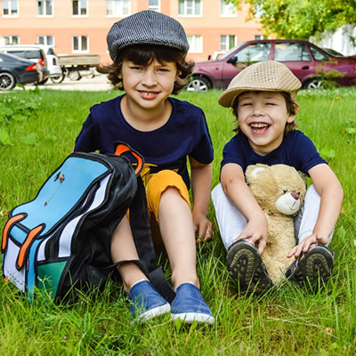 Kids sitting on grass with backpack