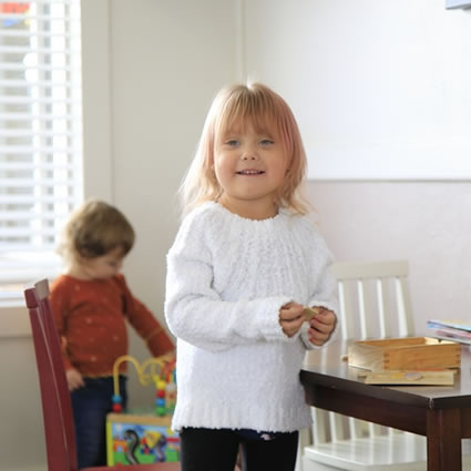 Little girl smiling in the play area.