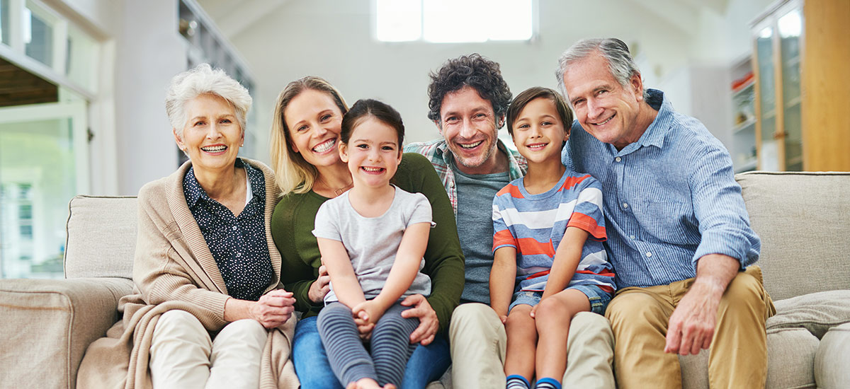 smiling family sitting on a couch