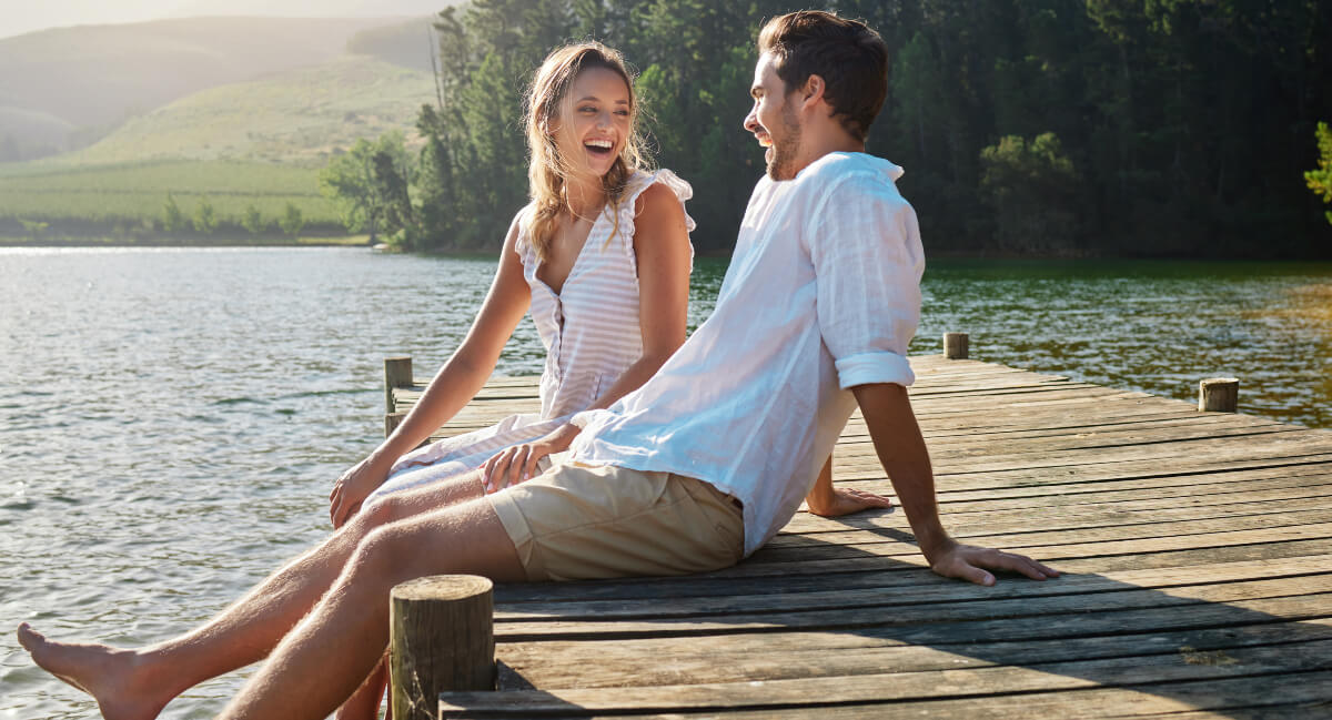 Laughing man and woman sitting at peer