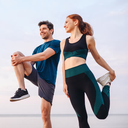 Male and female athletes stretching