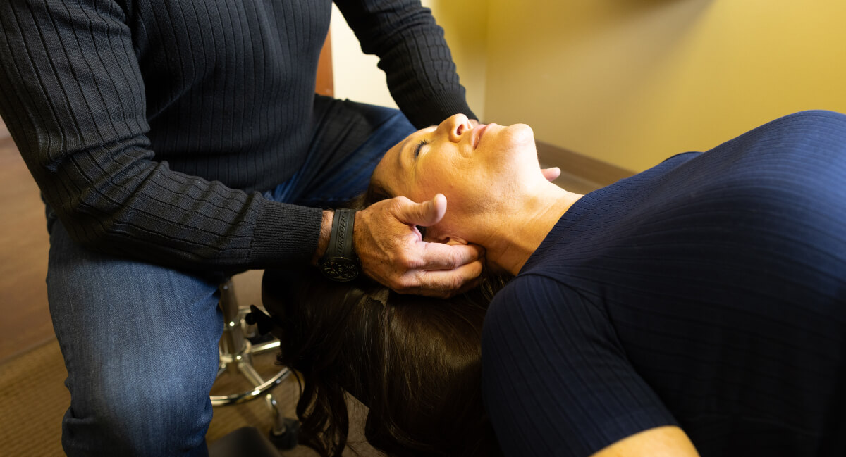 Pflugerville chiropractor adjusting patient's neck