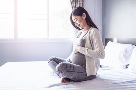 pregnant woman holding her baby bump