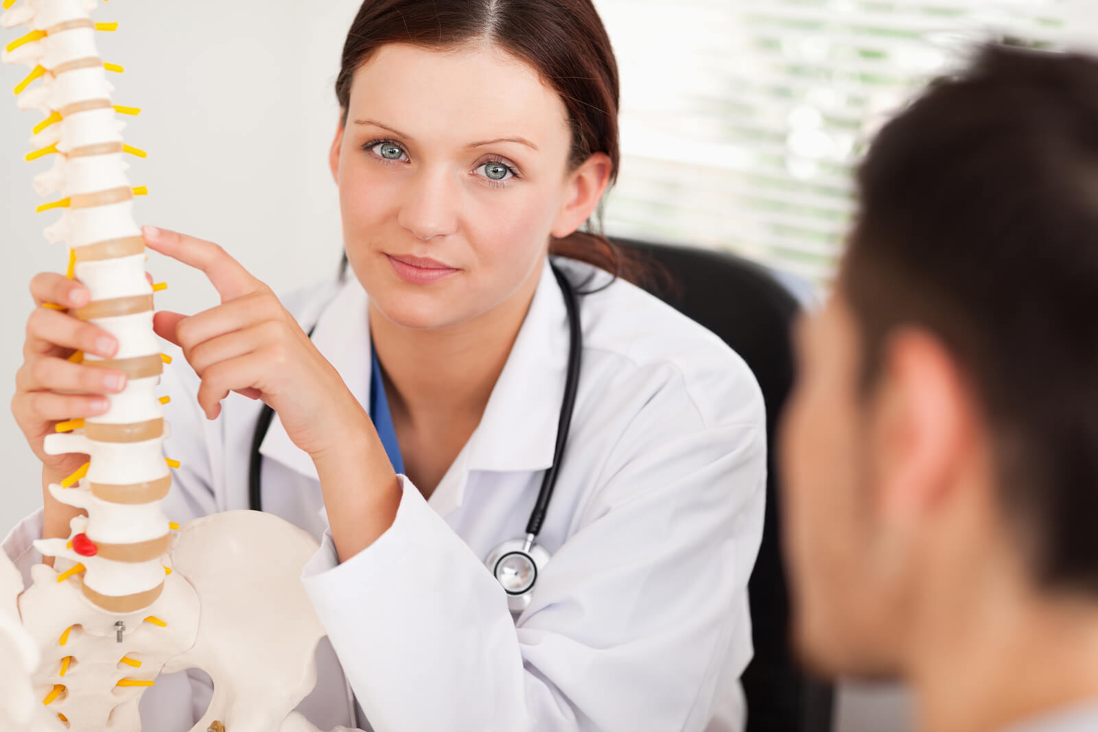 A Female Doctor Showing Patient A Spine