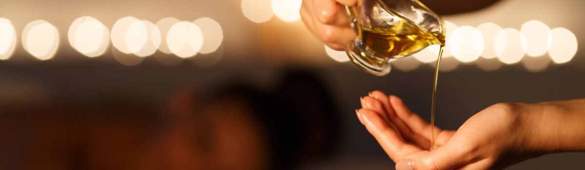 person pouring massage oil into their hand