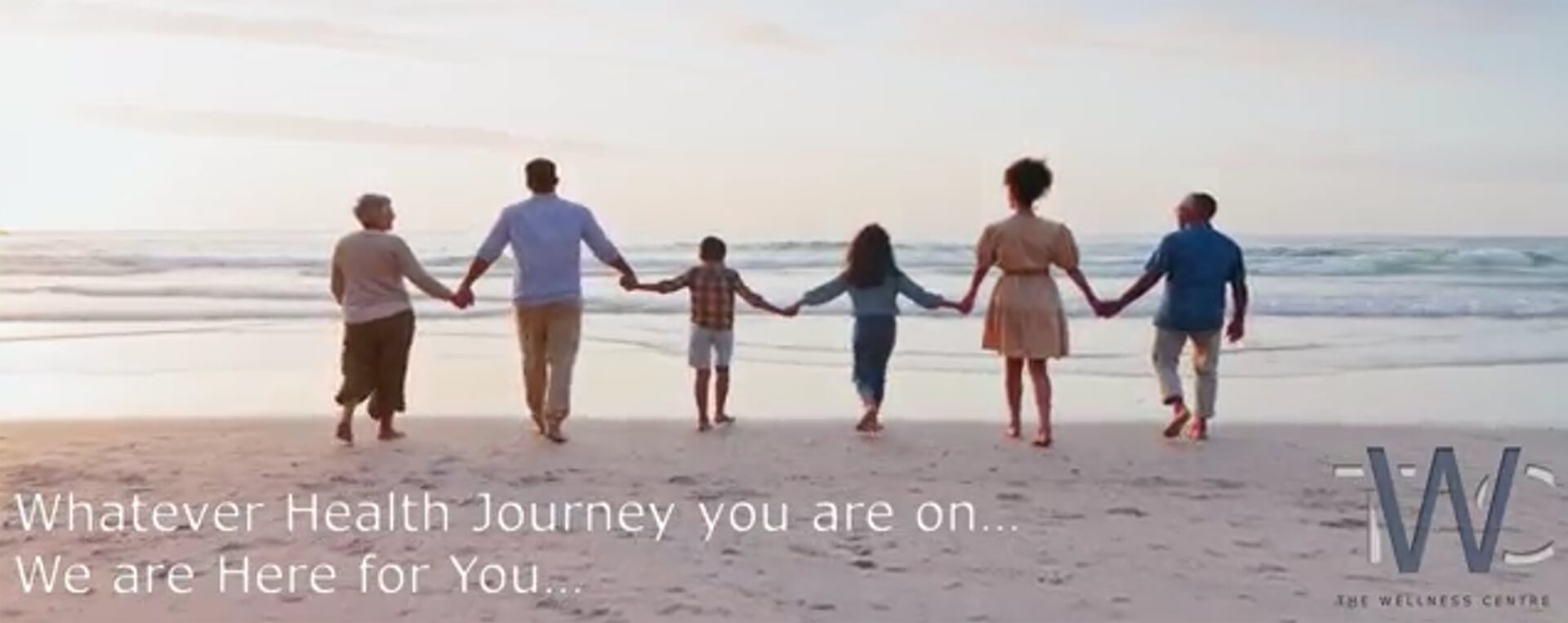 people holding hands and walking on beach
