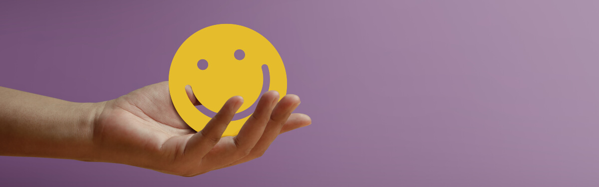 person holding shape of a purple smiley face