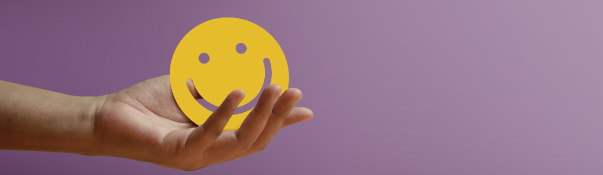 person holding shape of a purple smiley face