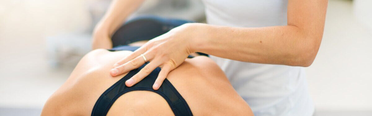 person in sports bra having back massaged