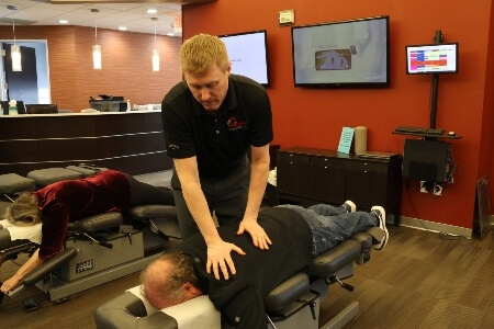 Chiropractor adjusting patient's upper-back